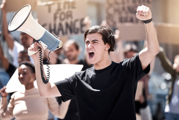 誰がやるか分からない。抗議中にメガホンで叫んでいた若い男が - 写真・画像
