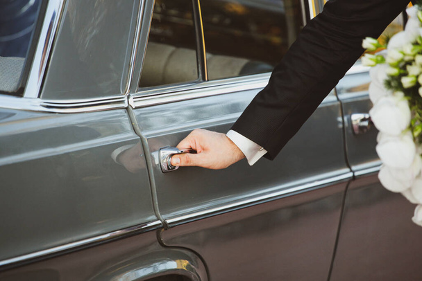 Close-up of a man's hand opening the car door to a woman. Gesture of gallantry. - Photo, Image