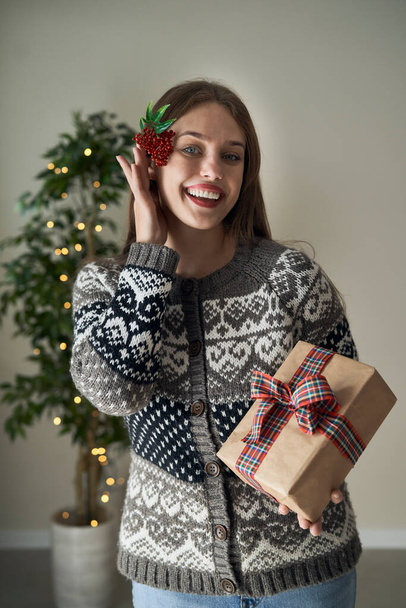 Λευκή γυναίκα που κρατάει δώρο Χριστουγέννων στα χέρια της  - Φωτογραφία, εικόνα