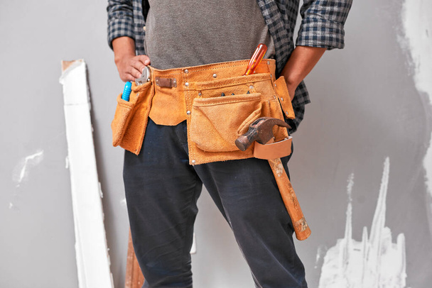Primer plano recortado de un hombre con un cinturón de herramientas con herramientas para el hogar DIY. Foto de alta calidad - Foto, Imagen