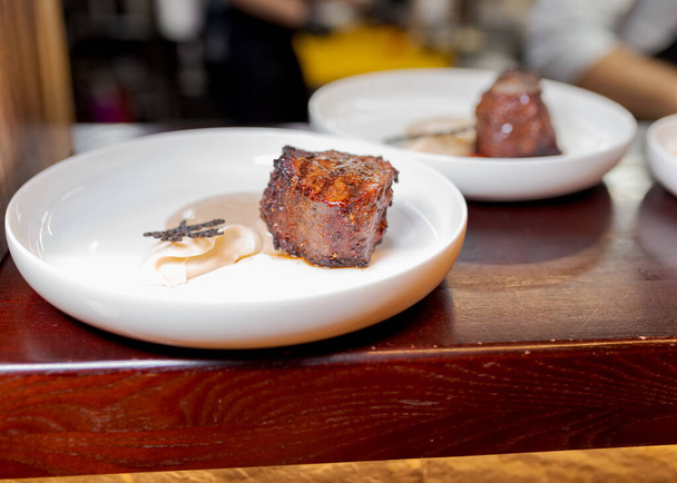 stek mięsny na talerzu w sosie na blat w kuchni restauracji - Zdjęcie, obraz