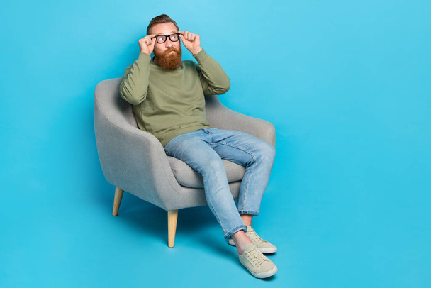 Full size photo of intelligent man with red hairstyle wear khaki pullover touch glasses look empty space isolated on blue color background. - Foto, imagen