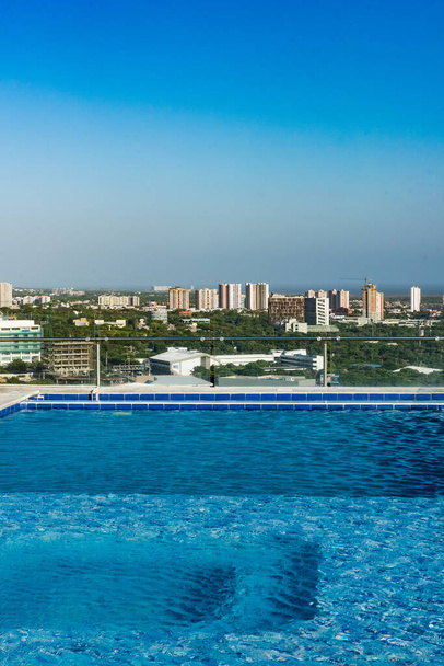 Barranquilla, Atlántico, Colombia. 30 de julio de 2022: Piscina desde un edificio y vista hacia la ciudad con hermoso cielo azul. - Foto, Imagen