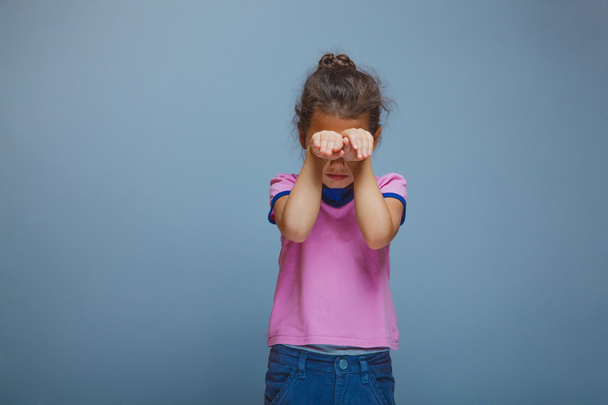 lány csukott szemmel kezét, egy szürke háttér - Fotó, kép