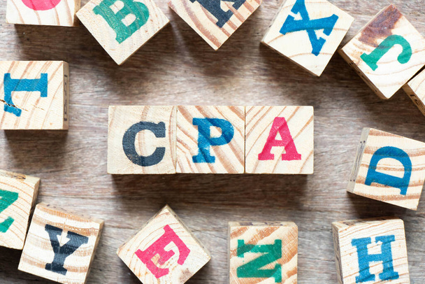 Alphabet letter block in word CPA (Abbreviation of Certified public accountant) and another letter on wood background - Photo, Image