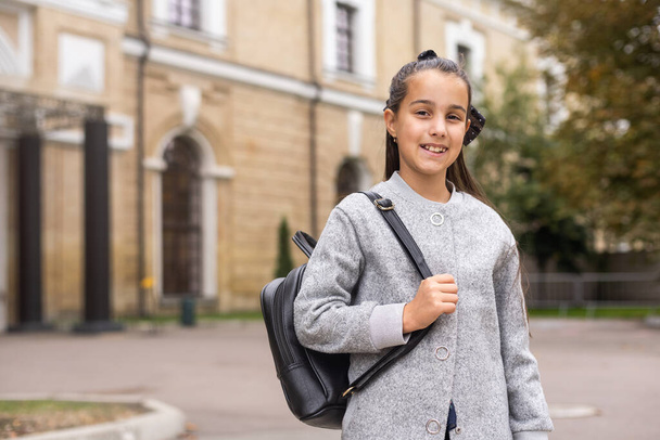 Preteen girl child with backpack outdoors. Pretty schoolgirl going home after class. - Photo, Image
