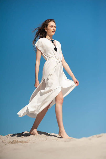 bella giovane donna in abito bianco in posa sulla spiaggia - Foto, immagini