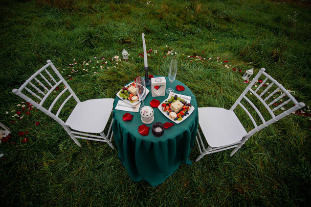 A romantic date on the hill for two : candles, wine, fruits, sweets. - Photo, Image