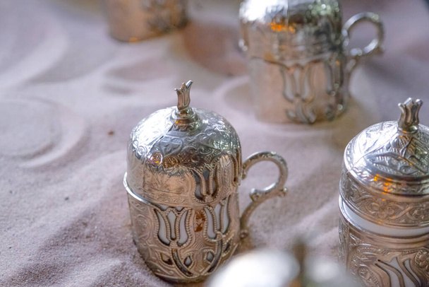 Медные чашки с турецким кофе, приготовленные в горячем песке. Путешествие в Турцию. - Фото, изображение