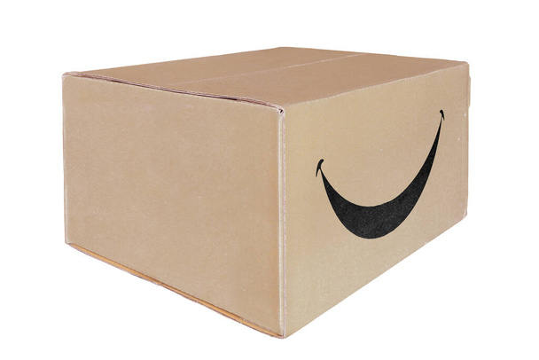 Κλειστό χαρτονένιο κουτί με μια πινακίδα χαμόγελου, απομονωμένο σε λευκό φόντο. - Φωτογραφία, εικόνα