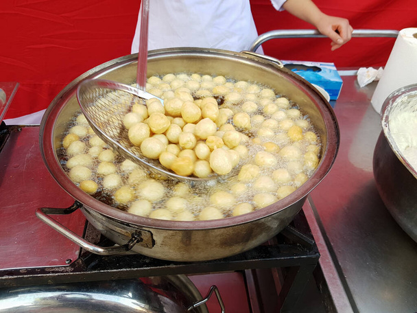 Cooking fry curd balls in boiling hot oil. Turkish donuts Lokma - 写真・画像