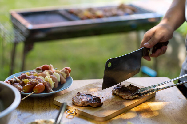 barbecue party voedsel zomer gegrild vlees Gelukkig vrienden hebben plezier grillen vlees, genieten van een barbecue partij en bier viering concept - Foto, afbeelding