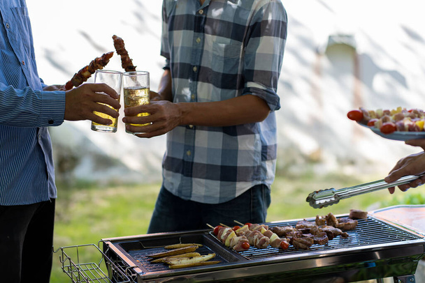 grilliruoka kesä grillattu liha Onnelliset ystävät pitävät hauskaa grillaavat lihaa, nauttivat grillijuhlista ja oluen juhlan konseptista - Valokuva, kuva