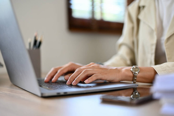Крупный план, профессиональная азиатская бизнесвумен или женщина-менеджер, работающая за своим столом, используя ноутбук, печатая на клавиатуре.  - Фото, изображение