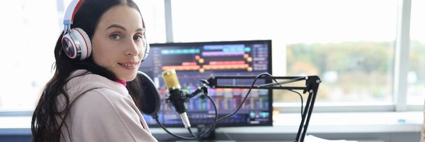 Disabled woman works as radio presenter in wheelchair in studio. Cybersport for disabled people concept - Фото, изображение