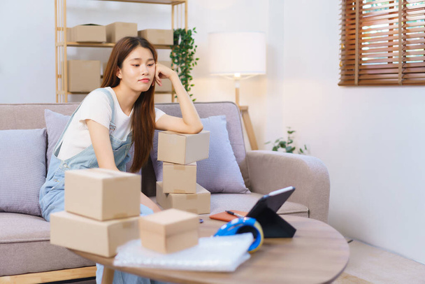 Online seller concept, Female entrepreneur feel exhausted after packing product in box for shipping. - Fotoğraf, Görsel