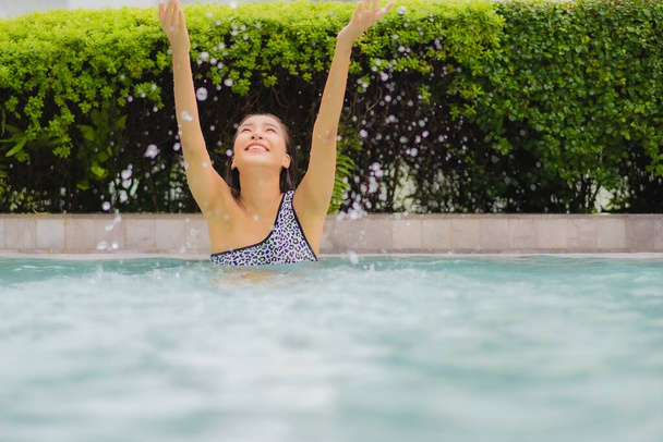 Portrét krásná mladá asijská žena relax úsměv kolem venkovního bazénu pro volný čas a dovolenou - Fotografie, Obrázek