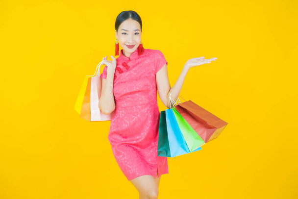 Portre güzel Asyalı kadın tebessümü ile renk arka planında alışveriş torbası - Fotoğraf, Görsel
