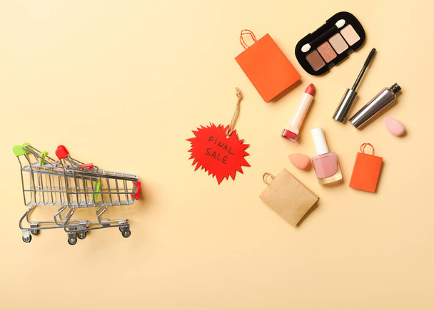 Shopping carts, decorative cosmetics and tag with text FINAL SALE on color background - Фото, зображення