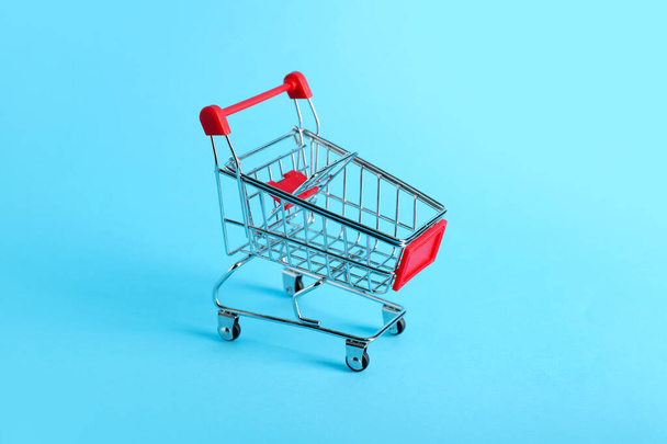 Red shopping cart on color background - Photo, image