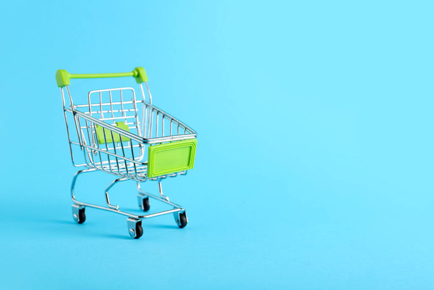 Green shopping cart on color background - Photo, Image