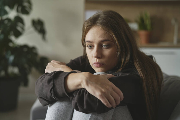 Femme triste caucasienne assise sur le canapé avec dépression - Photo, image