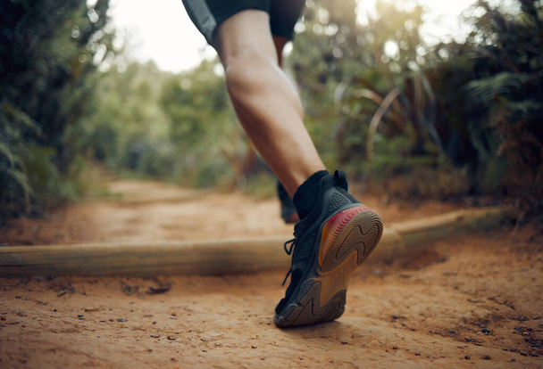 Hiking shoes, nature park trail running and fitness runner on a dirt walking road outdoor. Training, exercise and sport man on cardio, healthy and strong workout of an athlete doing morning sports. - Photo, Image