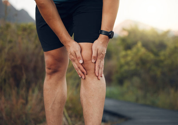 Knee pain, legs and arthritis of runner man, athlete and training, workout or exercise on hiking trail outdoors. Closeup bone fracture problem, muscle injury and body health risk for sports therapy. - Foto, immagini