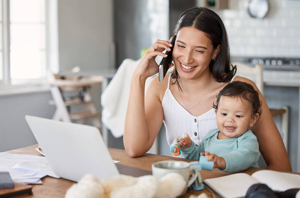 Jen máma, která má produktivní den. žena mluví na svém mobilu, zatímco sedí s notebookem a její dítě na klíně - Fotografie, Obrázek