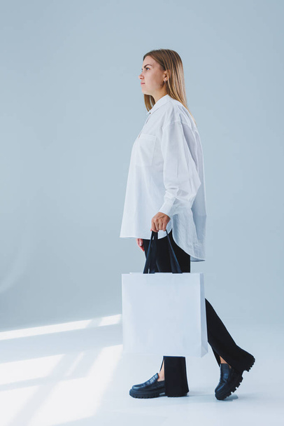 Femme élégante sur fond blanc avec un sac à provisions. Sac écologique pour faire du shopping. - Photo, image