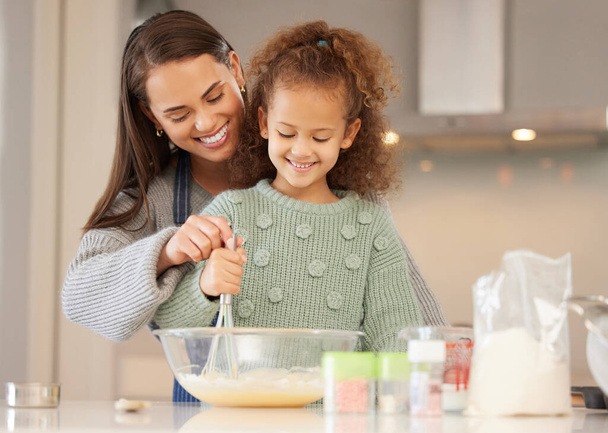 It smells delicious already. a mom baking with her daughter in their kitchen at home - Foto, imagen