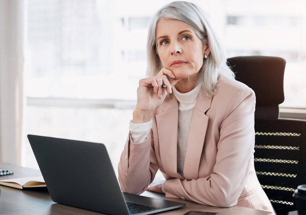 I have so much to get through today. a mature businesswoman sitting alone in the office and looking contemplative while using her laptop - Foto, Imagem