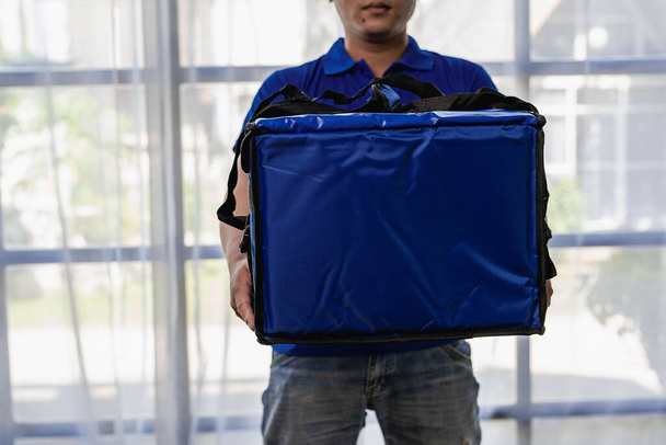 The delivery man was wearing a blue uniform and a bag. Deliver food or express parcel. Delivery man or express parcel isolated on white background. - Foto, Imagen