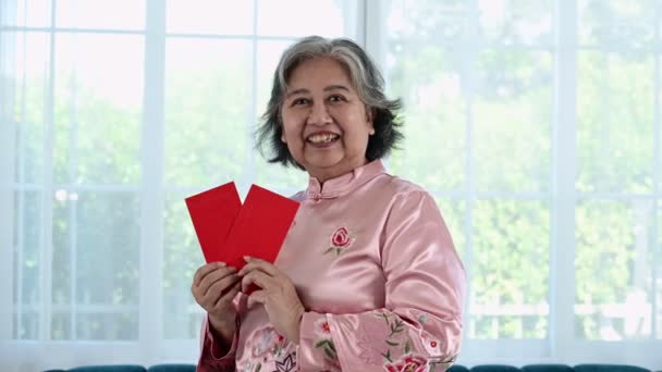 Ασιάτισσα γυναίκα κρατώντας κόκκινο φάκελο τσέπη για ευτυχισμένη κινεζική Πρωτοχρονιά γιορτές - Πλάνα, βίντεο