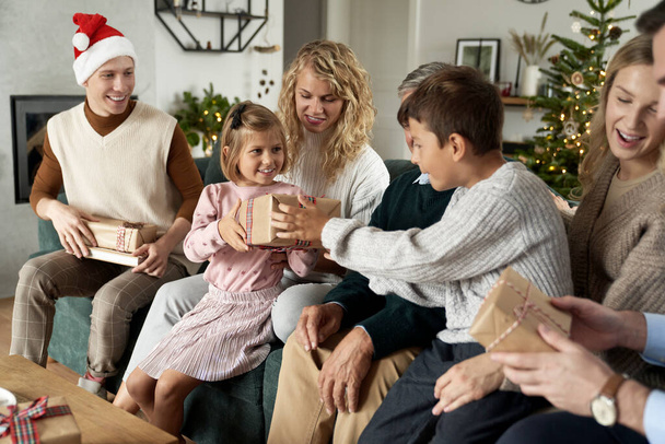 Мультипоколение кавказской семьи делятся рождественскими подарками и веселятся - Фото, изображение