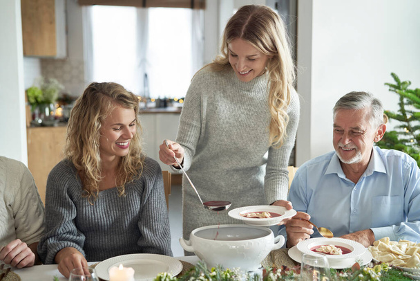 Valkoihoinen perhe alkaa syödä perinteistä puolalaista keittoa jouluaattona.    - Valokuva, kuva