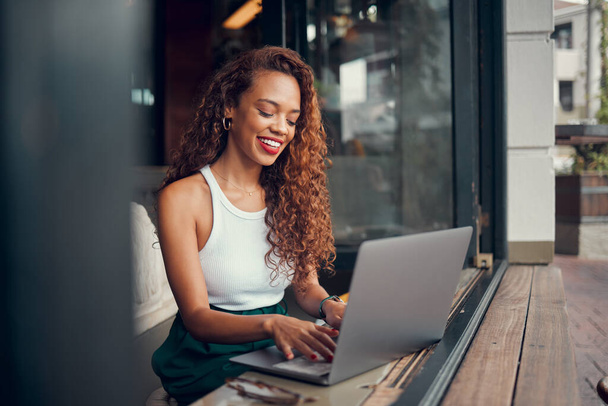 Fekete nő, távoli munka a laptop és kávézó 5g wifi hálózati kapcsolat kávézó dolgozik írás blog online. Professzionális digitális szabadúszó, boldog internetes író és gépelés mosollyal. - Fotó, kép