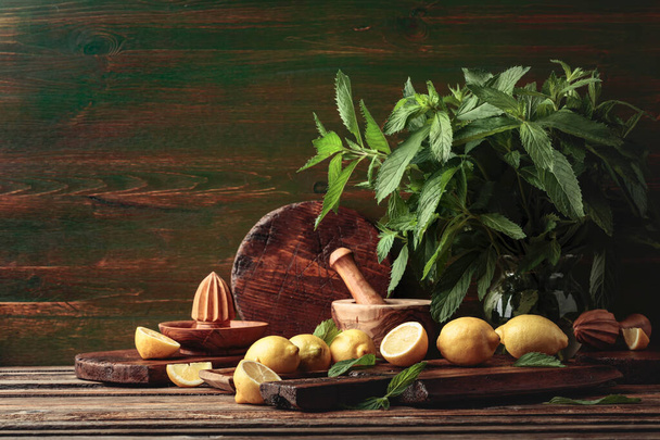 Fresh juicy lemons with mint on the old wooden table. Copy space. - Foto, immagini