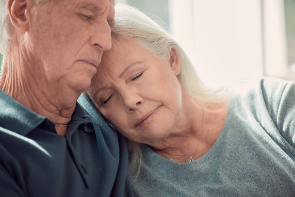 Safe and sound. an affectionate senior couple sitting in their living room at home - Foto, Imagen