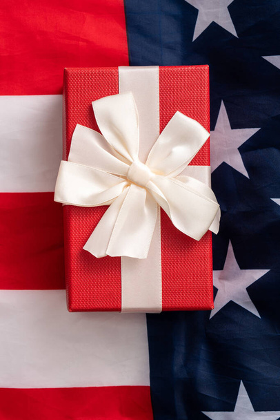 Designkonzept für die Wahlen in den Vereinigten Staaten, Ansicht der amerikanischen Flagge über weißem Tischhintergrund mit Geschenkbox. - Foto, Bild