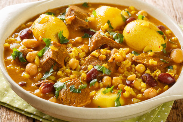 Jewish Cholent Hamin prepared is Israel as the main dish for the Shabbat meal made with beef, potato, beans, barley, and more  closeup in the pan on the table. Horizonta - Photo, Image