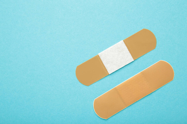 Adhesive bandage sticking plaster on blue background. Space for text. Top view - Foto, Imagem