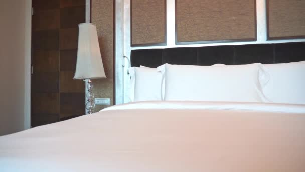 Λευκά μαξιλάρια και κουβέρτα στο κρεβάτι διακόσμηση του ξενοδοχείου υπνοδωμάτιο εσωτερικό  - Πλάνα, βίντεο