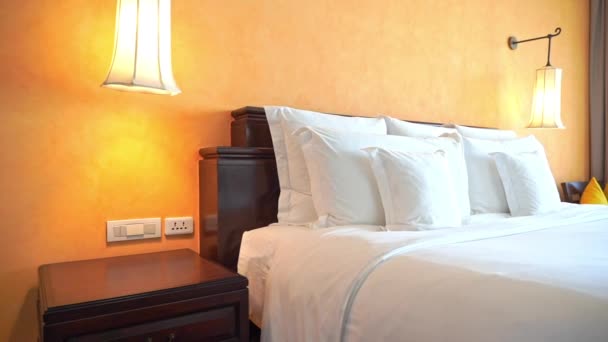 Λευκά μαξιλάρια και κουβέρτα στο κρεβάτι διακόσμηση του ξενοδοχείου υπνοδωμάτιο εσωτερικό  - Πλάνα, βίντεο