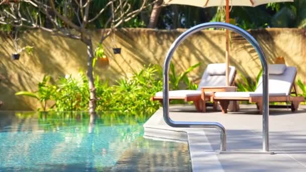 Lettini intorno alla piscina all'aperto in hotel resort per vacanze di viaggio - Filmati, video