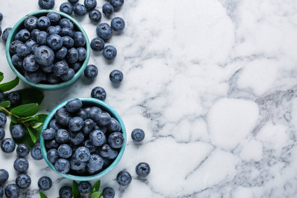 Tasty fresh blueberries on white marble table, flat lay. Space for text - 写真・画像
