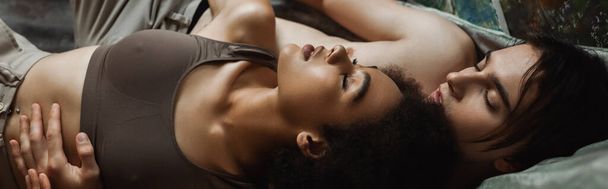top view fiatal félmeztelen művész ölelés csábító afro-amerikai barátnő műhelyben, banner - Fotó, kép