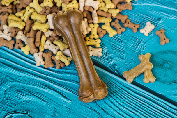 Huesos de perro y galletas sobre fondo de madera turquesa - Foto, Imagen
