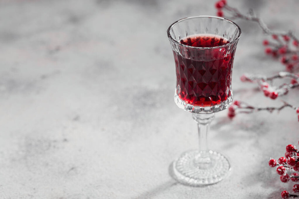 Glass of cherry liqueur or wine on white background. Christmas or new year party celebration concept. Winter holidays concept. - 写真・画像