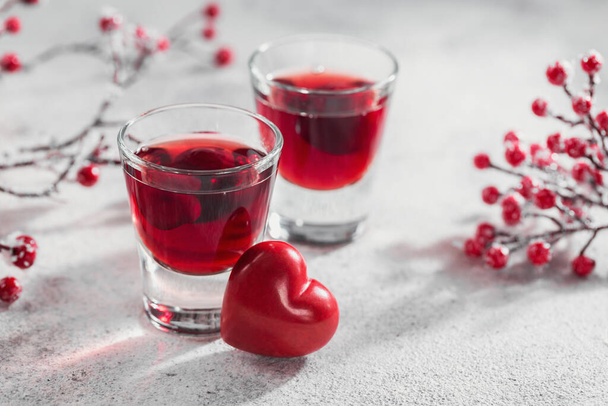 Red cocktail, vodka or liqueur and Heart shape decorations on white background. Happy Valentines day concept. - Foto, Imagen